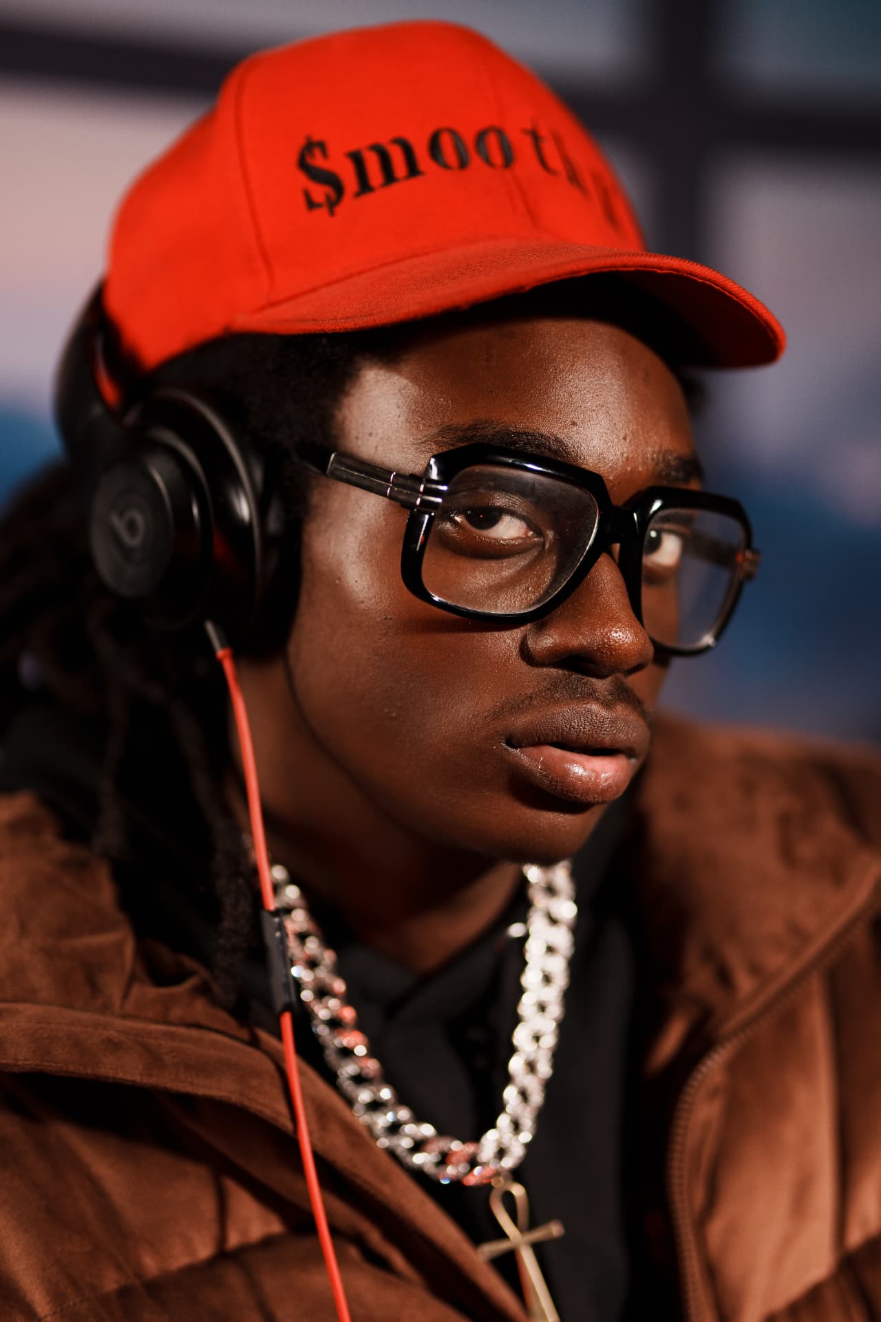 Artist wearing a red cap and headphones in the studio